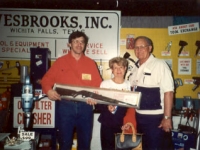 Mike Grauerholz of Wesbrooks, Inc. presenting the rifle to the lucky winners at the 1993 NATSO Truck Stop Show in Orlando.